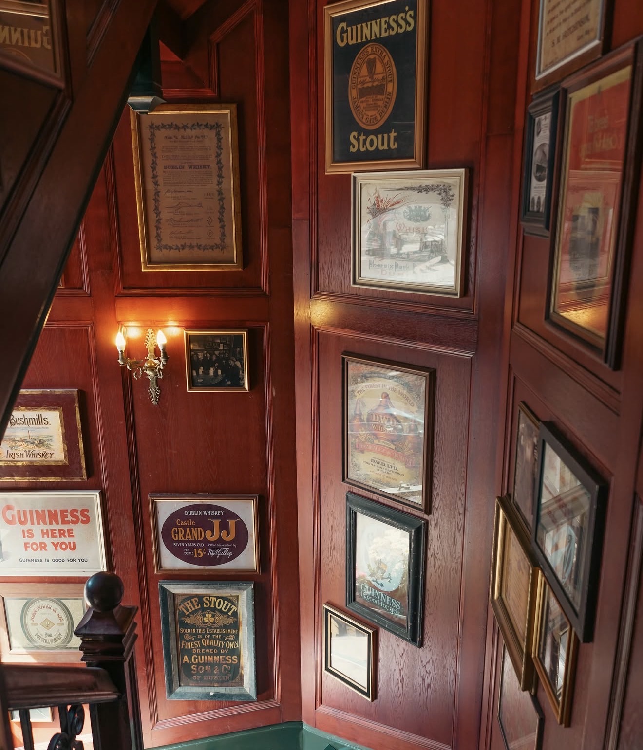 Vintage Irish whiskey and Guinness advertising framed on the stairwell wall